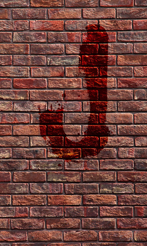Blutiges J an einer Backsteinmauer
